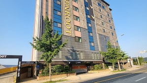 Un edificio de hotel de varios pisos con un llamativo letrero 'GOLDENROOT'.