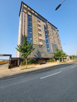 Un edificio de hotel de varios pisos con un llamativo letrero 'GOLDENROOT'.