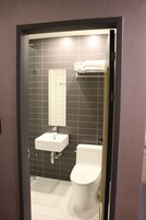 Un baño con un lavamanos blanco, un inodoro y un espejo.