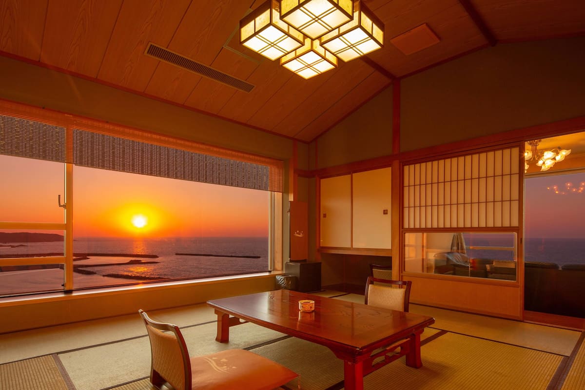 Une pièce de style japonais traditionnel, avec un sol recouvert de tatamis, une basse table en bois et des portes coulissantes en papier de riz (shoji).