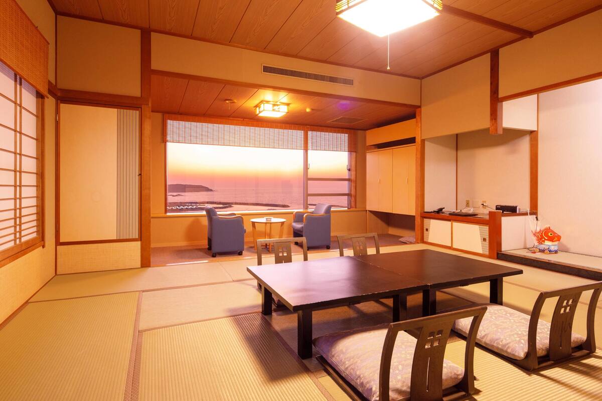 Une pièce de style japonais traditionnel, avec un sol recouvert de tatamis, une table basse et des sièges.