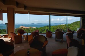 A modern interior with large windows offering a scenic view of a bridge and hills. - Awaji Island Uzushio Onsen Umemaru (Minamiawaji)