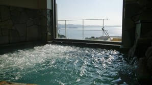 Een hottub met uitzicht op zee door een raam.