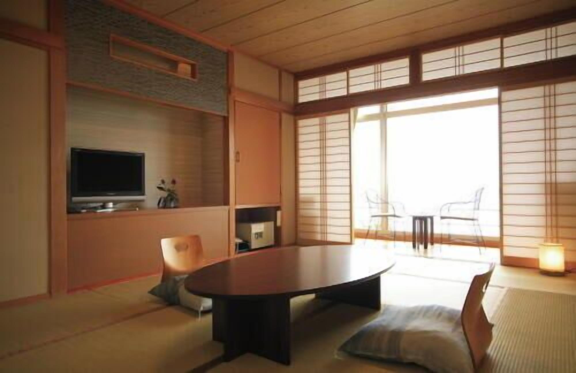 A traditional Japanese-style room with tatami flooring, a low table, and sliding doors.