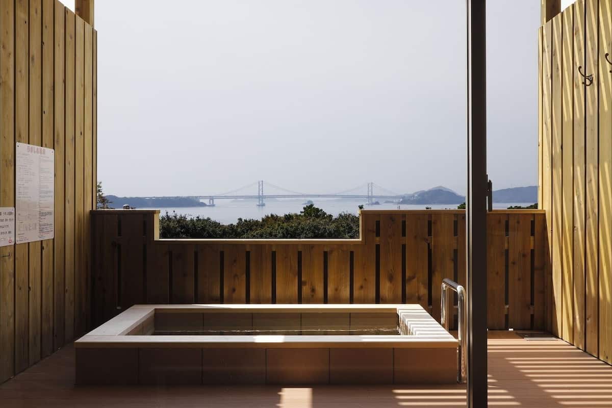 Una habitación con piso de madera y vistas a un puente y montañas.
