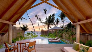 A wooden deck with a pool, lounge chairs, and a wooden table with chairs. - Fushifaru Maldives (Fushifaru)