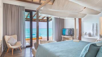 Habitación de hotel con una cama grande, televisión, escritorio y vistas al océano.