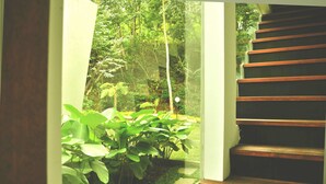 A staircase leading to a lush garden area with a checkered path and green plants. - VillaTel Salse (Bandung)