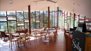 A restaurant with large windows, wooden furniture, and a Samsung sign. - VillaTel Salse (Bandung)
