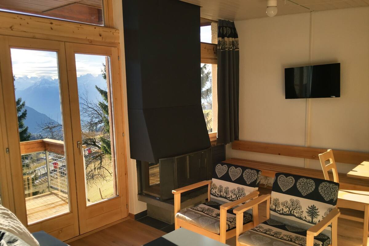 A cozy room with a fireplace, wooden furniture, and a TV.