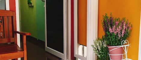 A hallway with a wooden bench, a door labeled '1A', and potted plants.