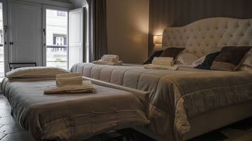 A hotel room with two beds, a large window, and a view of the outside.