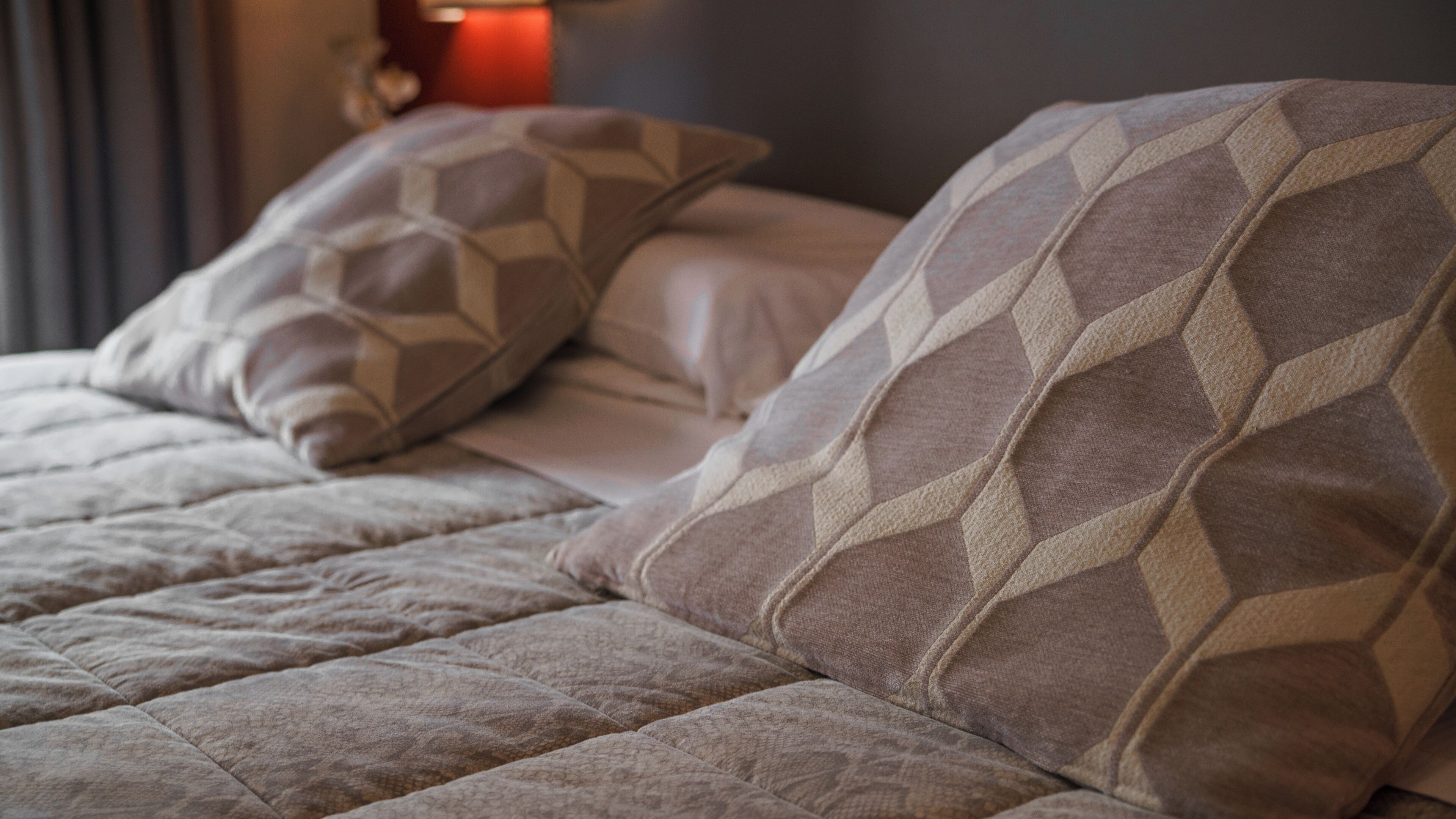 A bed with a patterned duvet cover and pillows.