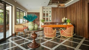 Un interior moderno con piso a cuadros, muebles de mimbre y una zona de bar con paneles de madera.
