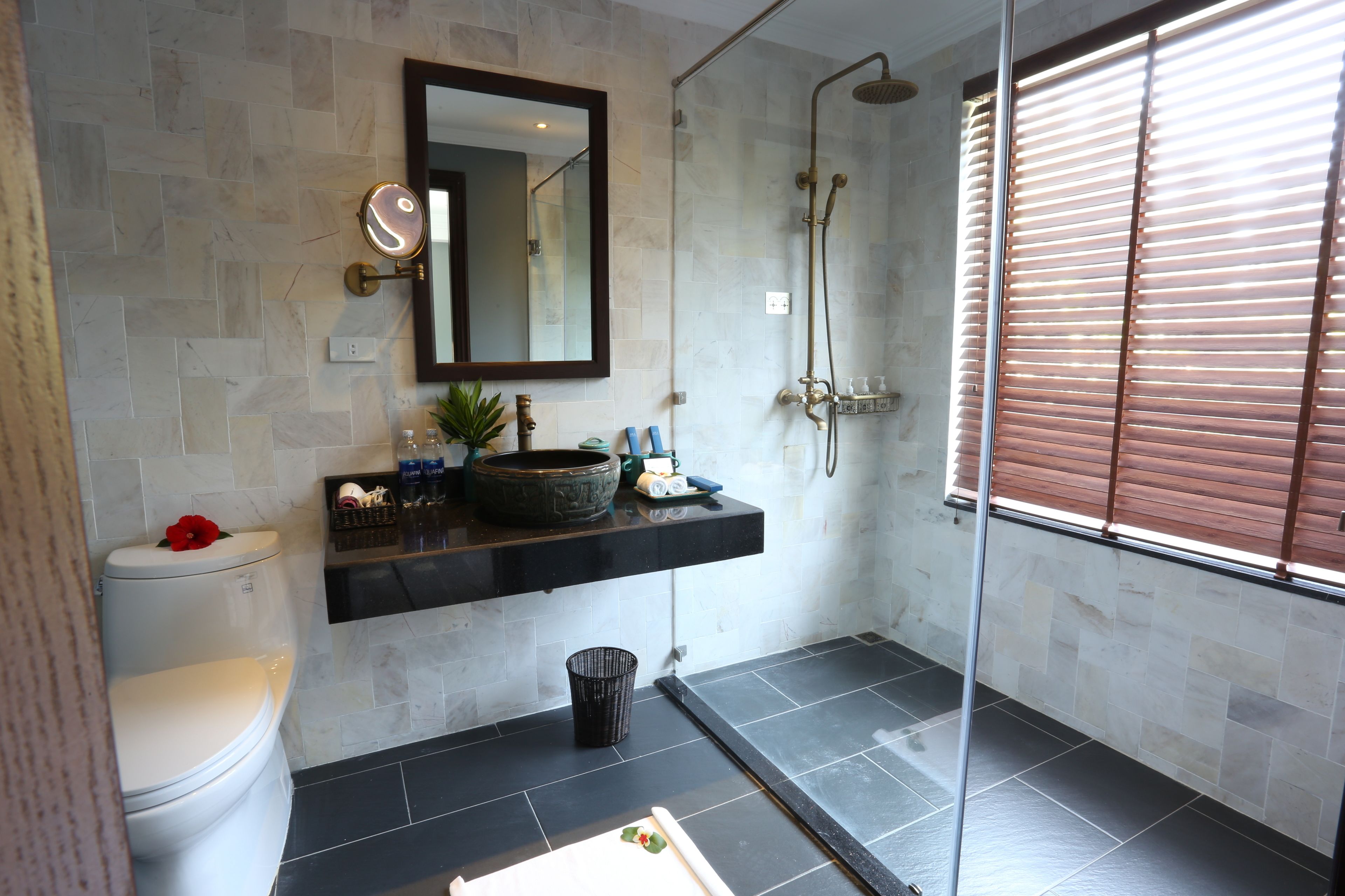 A modern bathroom with a toilet, sink, and shower.