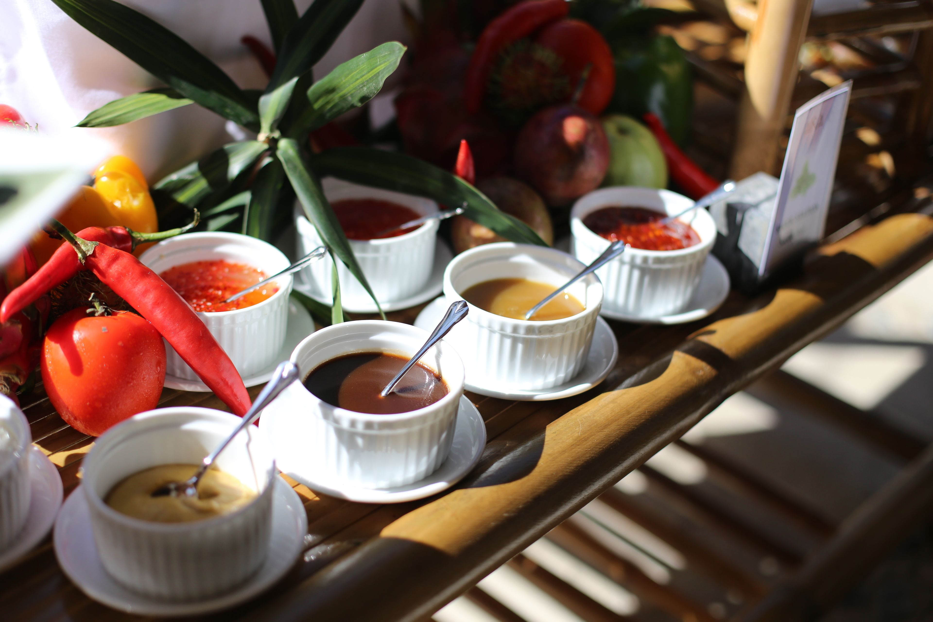 Une table avec de petits bols remplis de nourriture, quelques piments rouges et une plante.