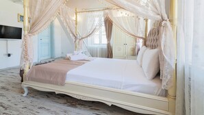 A four-poster canopy bed with a white bedspread and pillows, a bedside table with a lamp, and a large mirror on the wall. - Alacati Roka Tas Otel (Cesme)