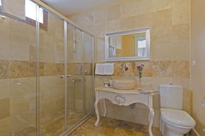 A bathroom with a glass shower enclosure, a vanity with a sink and mirror, and a toilet. - Alacati Roka Tas Otel (Cesme)