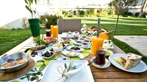 Una disposición para picnic con diversos alimentos y bebidas sobre una mesa al aire libre.