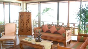 A spacious living area with a wooden sofa, a matching armchair, and a coffee table. - 4 Bedroom 300 degrees Sea View Villa SDV139A-By Samui Dream Villas (Koh Samui)