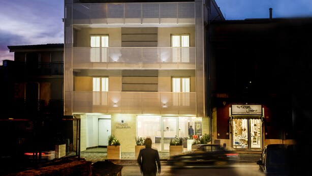 Un hotel moderno con fachada plana, amplias ventanas y una entrada visible.