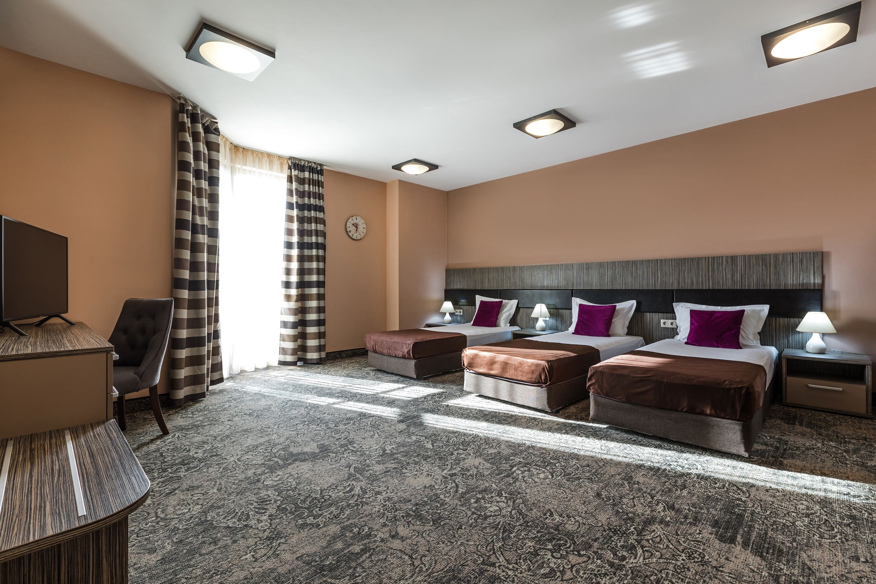 Habitación de hotel con una cama grande, dos mesitas de noche, un escritorio y una silla.