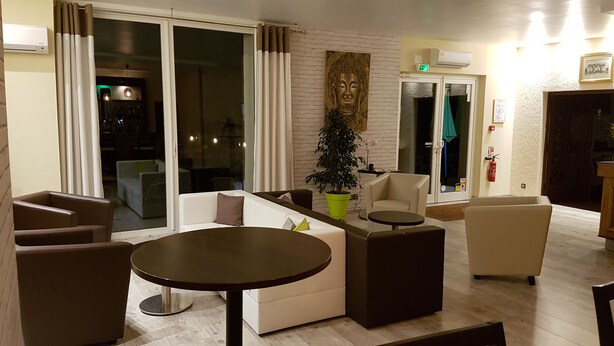 Una sala de estar moderna con un sofá, sillones, una mesa de centro y una planta en maceta.