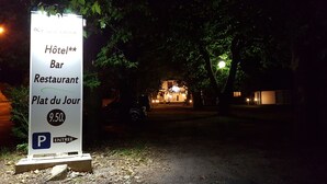 Señalización para un hotel, bar y restaurante llamado 'Hôtel Bar Restaurant Plat du Jour', con acceso a estacionamiento.