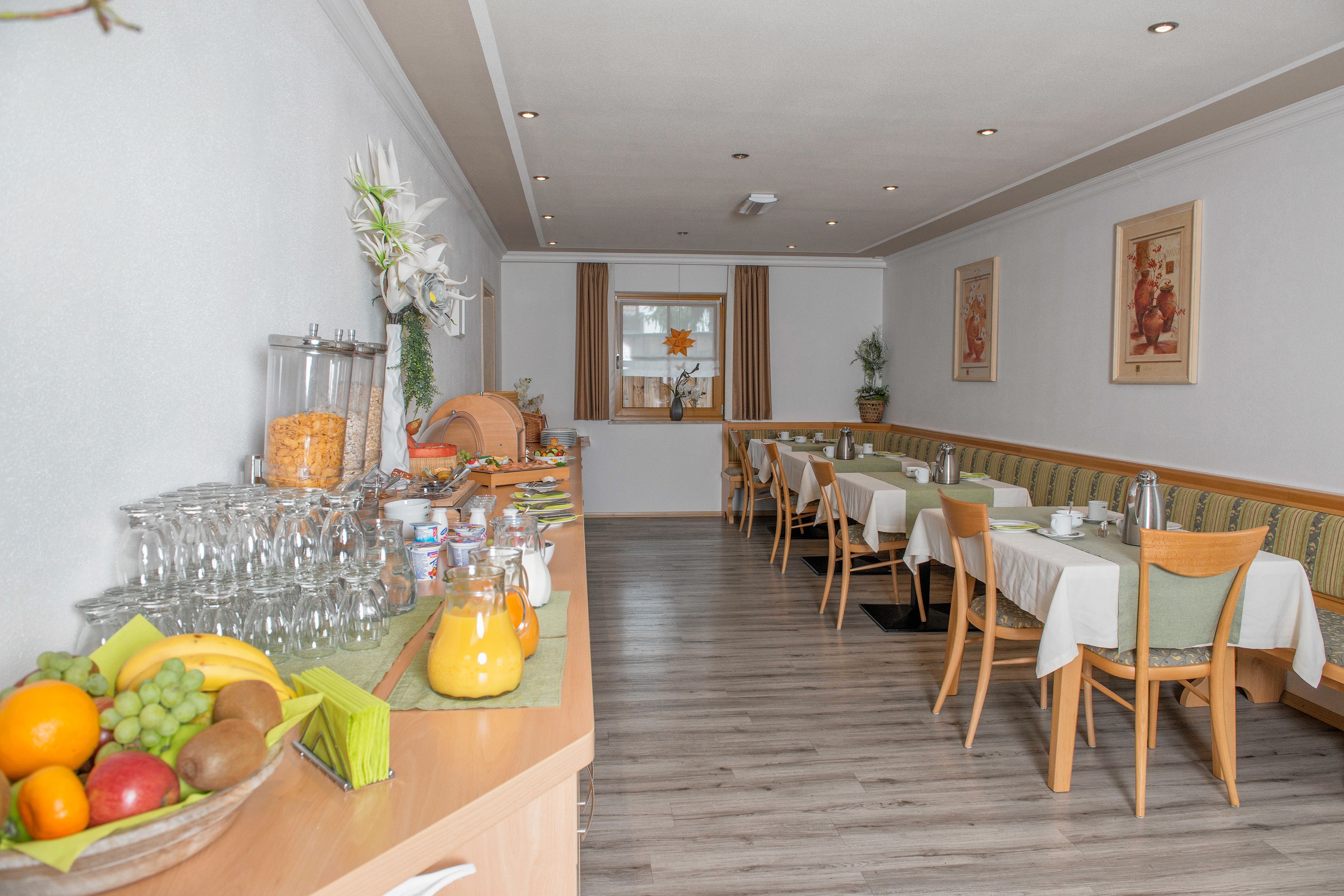 Un comedor con barra libre, que incluye frutas, bebidas y vasos.