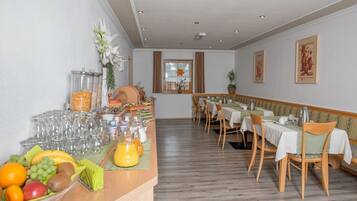 Un comedor con barra libre, que incluye frutas, bebidas y vasos.