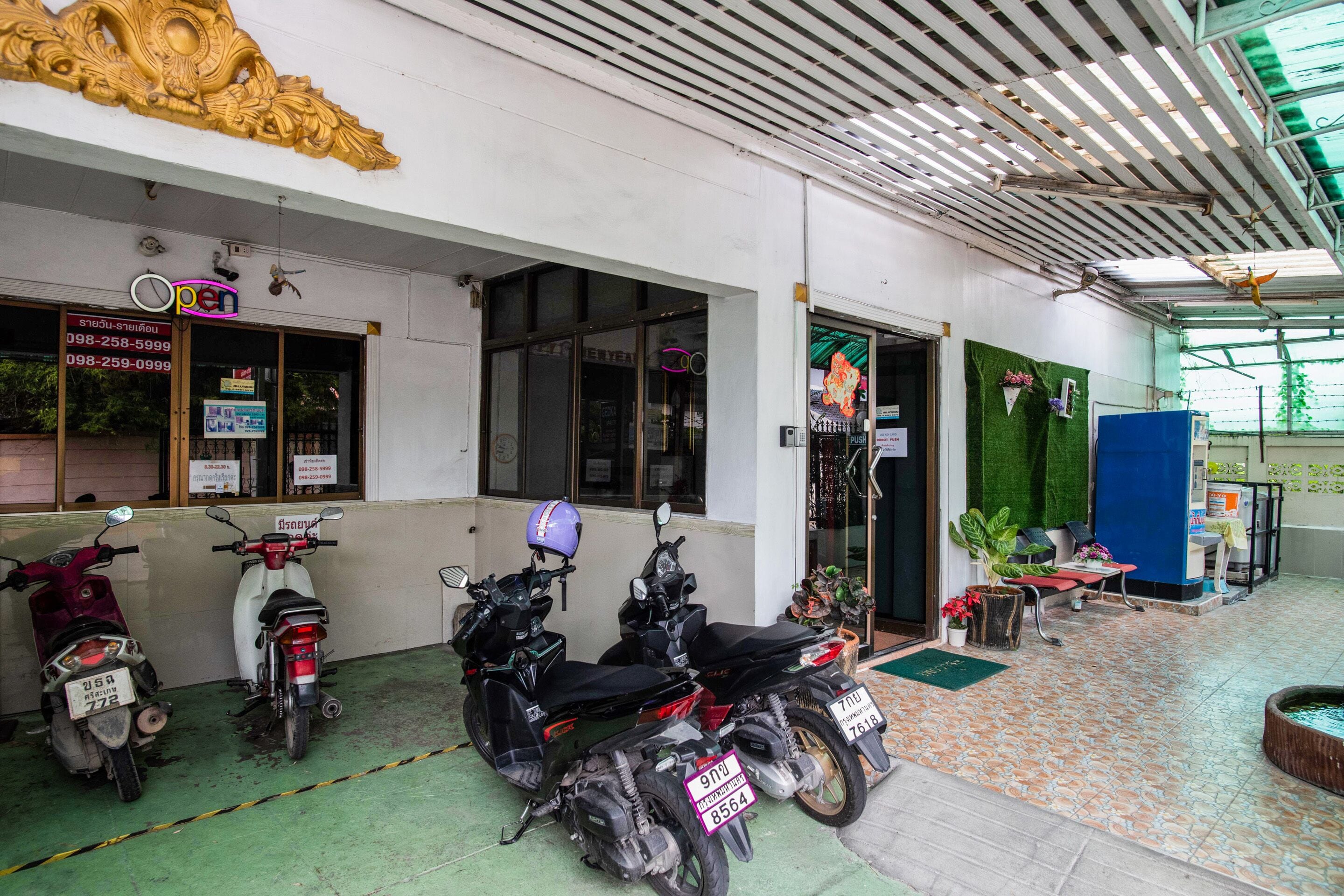 Un bâtiment avec une enseigne indiquant « Ouvert » et une rangée de motos garées.