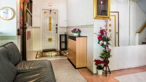 Rebedor d'hotel amb una recepció, un sofà, un rellotge i una escala.