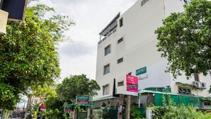 Edifici de diverses plantes amb una tenda verda i un cartell de pisos.
