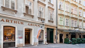 A building with the name 'ARTHUR GRIMM' on the facade, featuring large windows and a green door. - ElegantVienna Apartments (Vienna)
