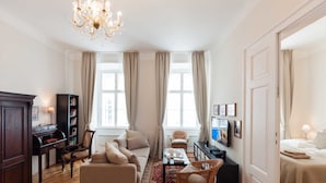 A well-lit living room with a chandelier, a sofa, a coffee table, a television, and a bookshelf. - ElegantVienna Apartments (Vienna)