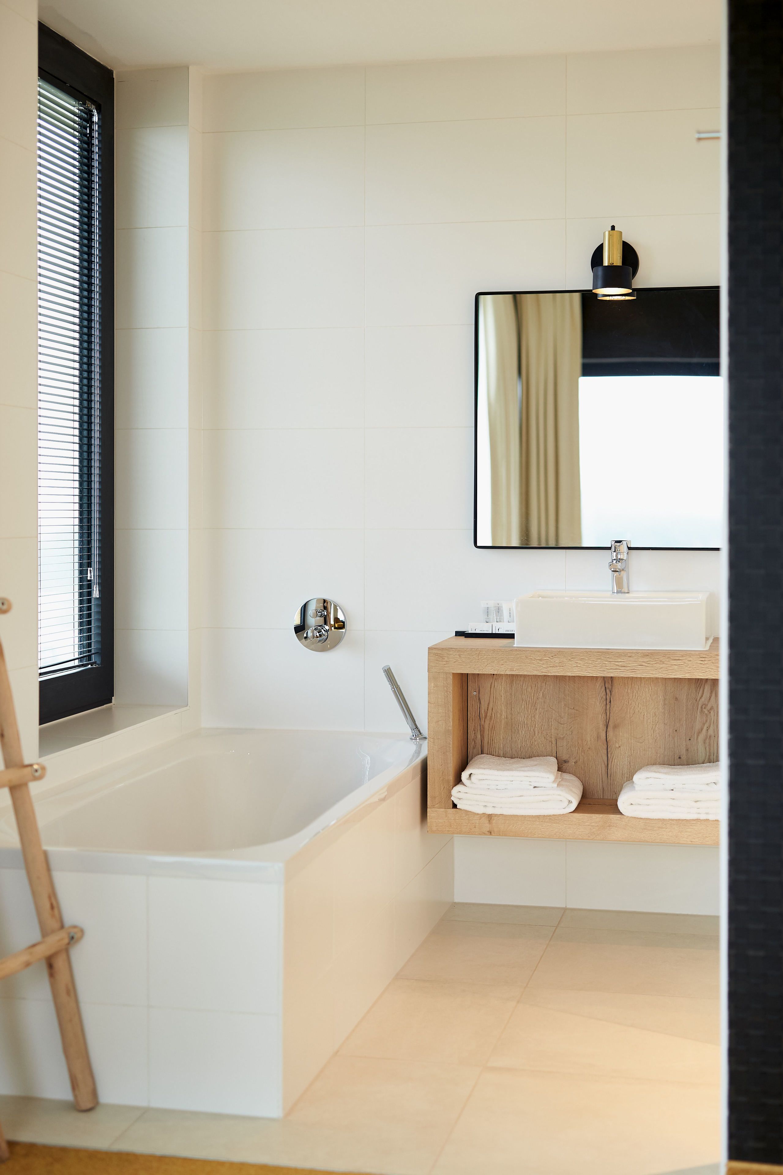 A modern bathroom with a bathtub, a sink, and a mirror.