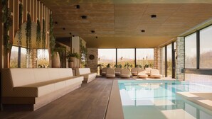 A modern indoor pool area with a long bench, lounge chairs, and large windows offering a view of the outdoors.