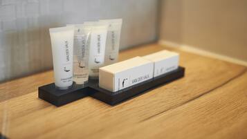A set of toiletries on a wooden tray in a hotel room.