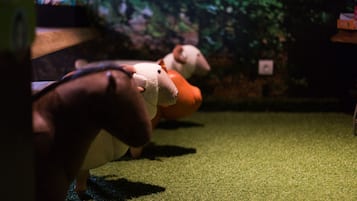 A plush toy sheep on a green carpet.