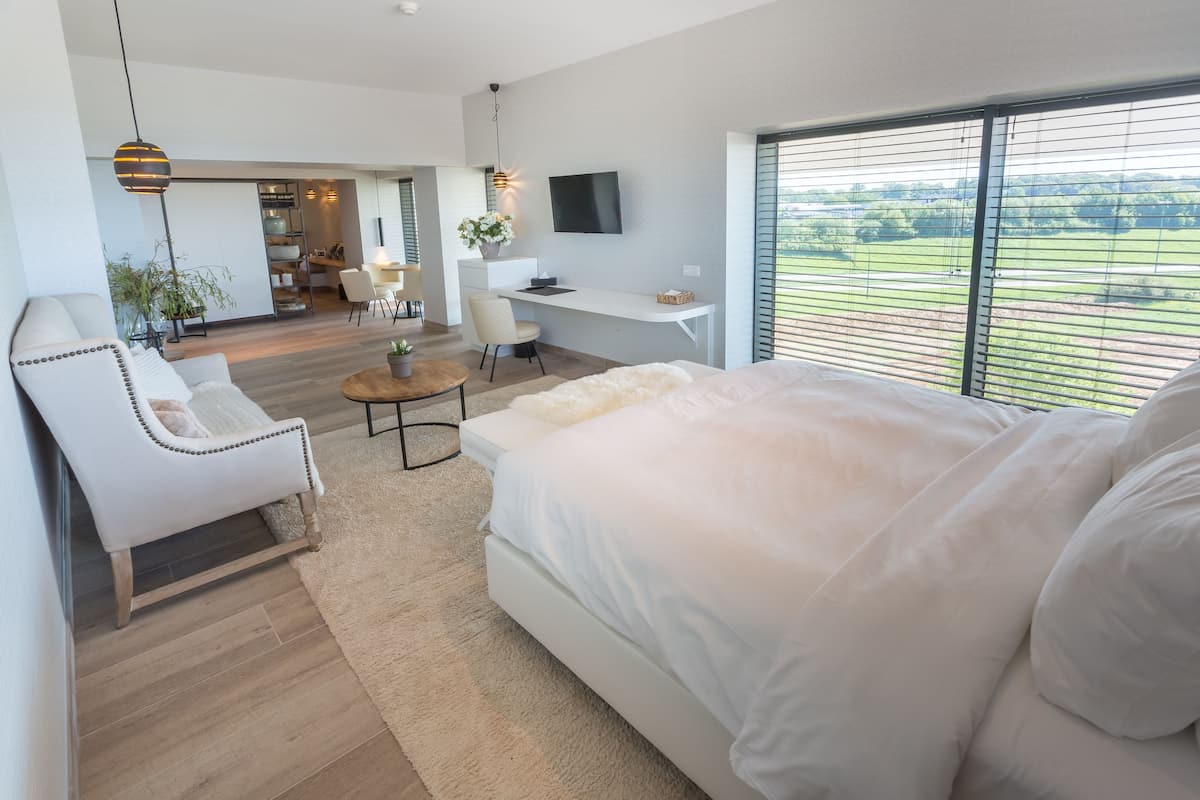 Un dormitorio moderno con una cama grande, un escritorio y un televisor.