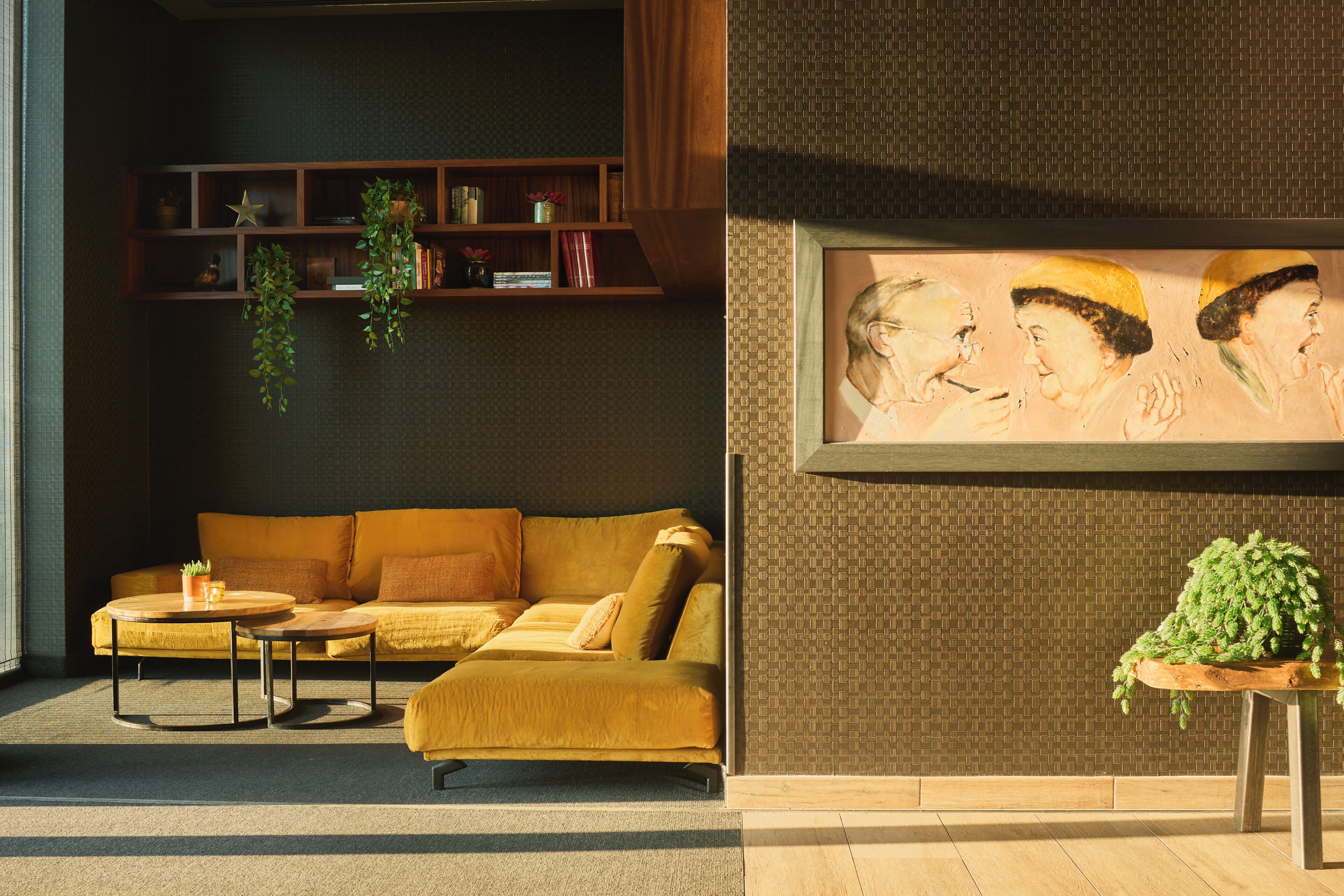 A modern living room with a sofa, coffee table, and a wall-mounted painting.