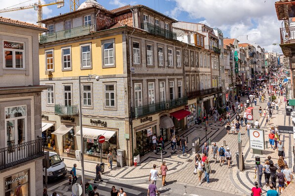 Escena callejera animada con edificios históricos, tiendas y peatones.