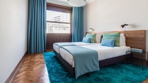 A modern bedroom with two beds, a large window with curtains, a wooden headboard, a nightstand, and a hanging light fixture. - YOUROPO - Santa Catarina (Porto)