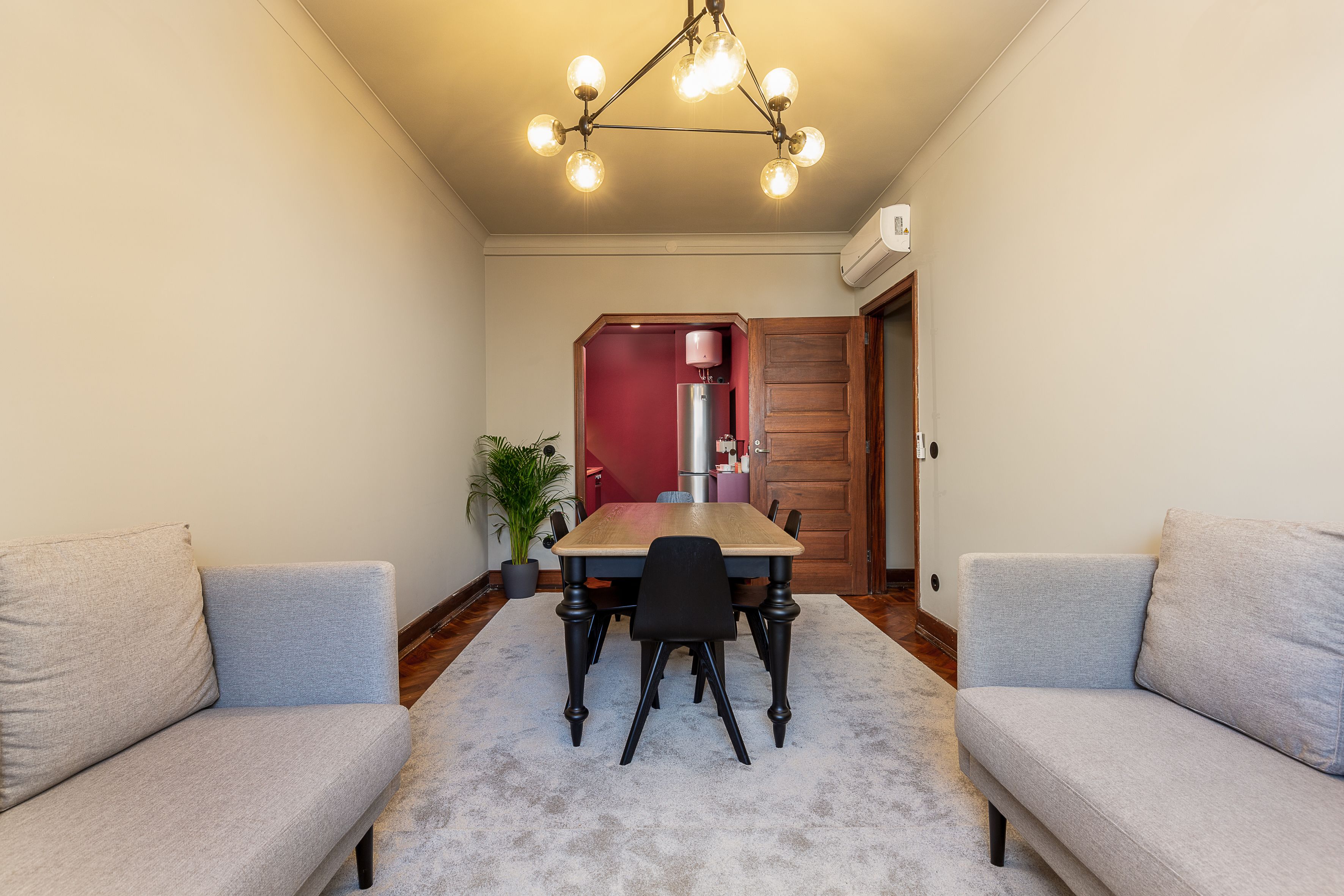 Un espace repas comprenant une table, des chaises et un lustre.