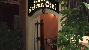 Een gebouwde ingang met een bord waarop 'Antik Ridvan Otel' staat.