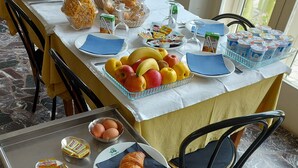 A breakfast buffet with croissants, fruits, and dairy products. - Hotel Naviglio (Pietrasanta)