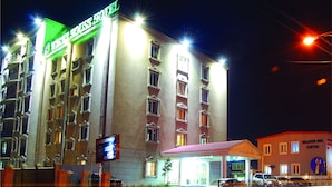 A hotel with multiple floors, a prominent sign, and a well-lit entrance. - White House Hotel (Ulaanbaatar)