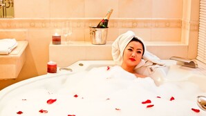 A bathtub with rose petals, a bottle of champagne, and candles. - White House Hotel (Ulaanbaatar)