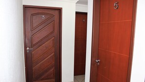 A hallway with three wooden doors, each marked with a number. - Hotel Pousada da Praça (Recife)