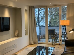 Departamento de lujo, 2 habitaciones, con acceso para personas discapacitadas, balcón | Área de sala de estar | Televisión de pantalla plana, películas con cargo y oficina